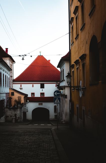 Charming Zagreb street view with historic architecture and striking red roof.