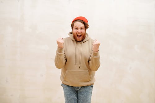 Free Man in Brown Sweatshirt with Clenched Fists Stock Photo