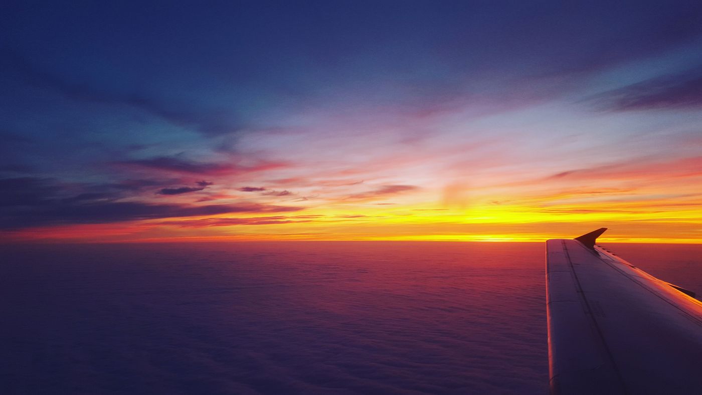 View of an airplane wing against a sunset sky