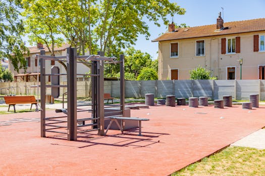 Public outdoor gym with exercise equipment in a sunny park in Saint-Priest, France.