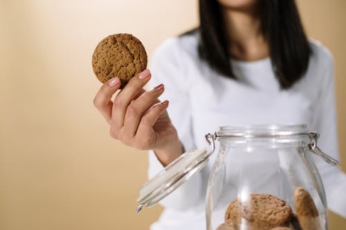 Kobieta W Białej Koszuli Z Długim Rękawem Trzyma Brązowy Plik Cookie