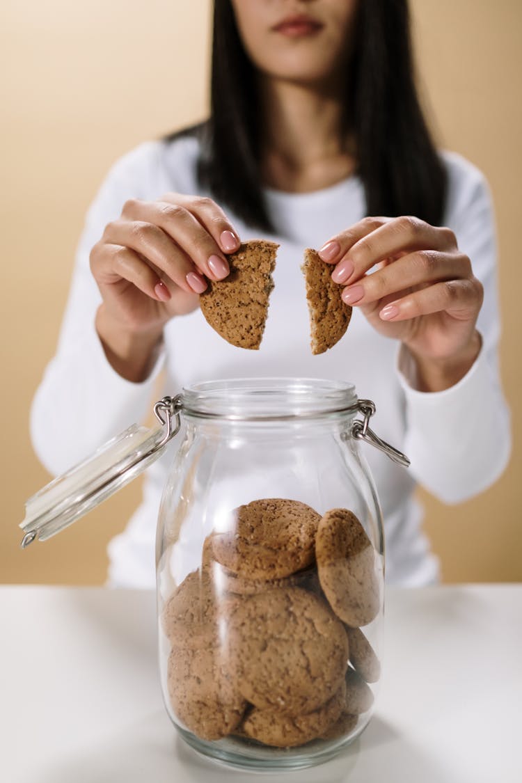 
A Woman Holding A Broken Cookie