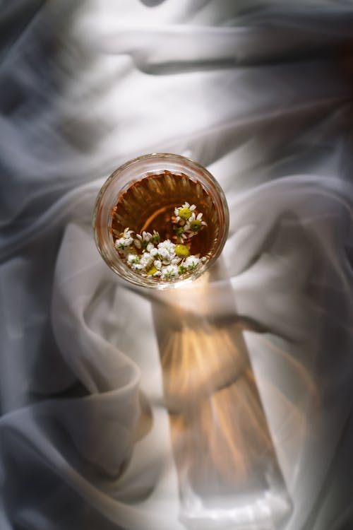 Glass of Chamomile Tea on a White Sheet