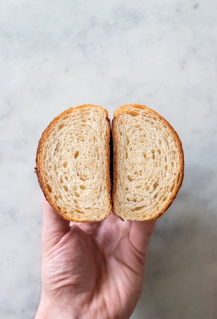 Hand Holding Pieces Of Bread