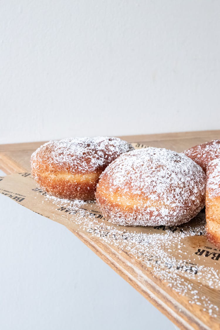 Powdered Donuts On Wooden Cutting Board