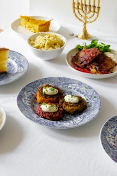 A traditional Jewish meal set up for Hanukkah with various dishes and a menorah.