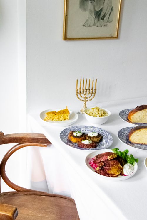Free A beautifully set Hanukkah dining table with traditional Jewish cuisine and decor. Stock Photo