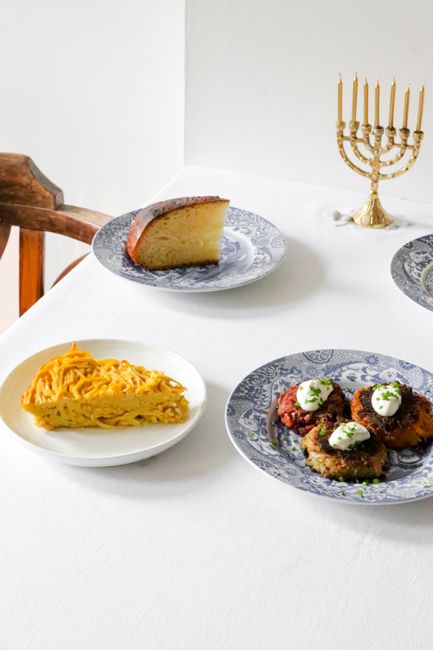 A festive Hanukkah table setting featuring traditional Jewish dishes with a menorah centerpiece.
