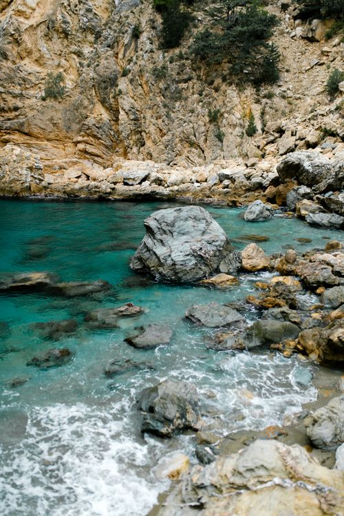Free Stunning view of a rocky shore with clear turquoise ocean waters. Stock Photo