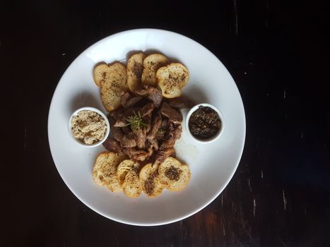 Savor a flavorful Brazilian meat dish served with crispy seasoned toasts.