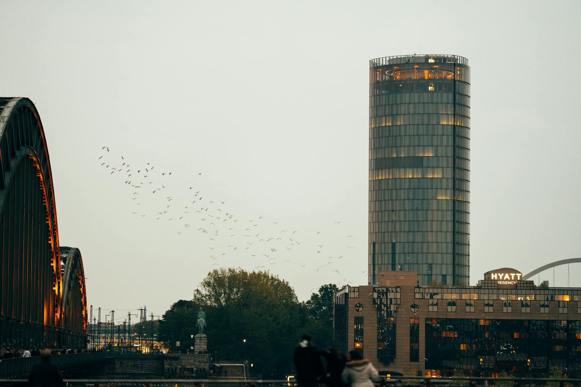 Urban skyline featuring a modern tower, bridge, and Hyatt Regency at dusk.