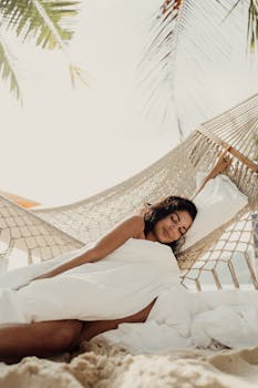Serene image of a woman relaxing in a hammock by the beach, capturing a peaceful vacation vibe.