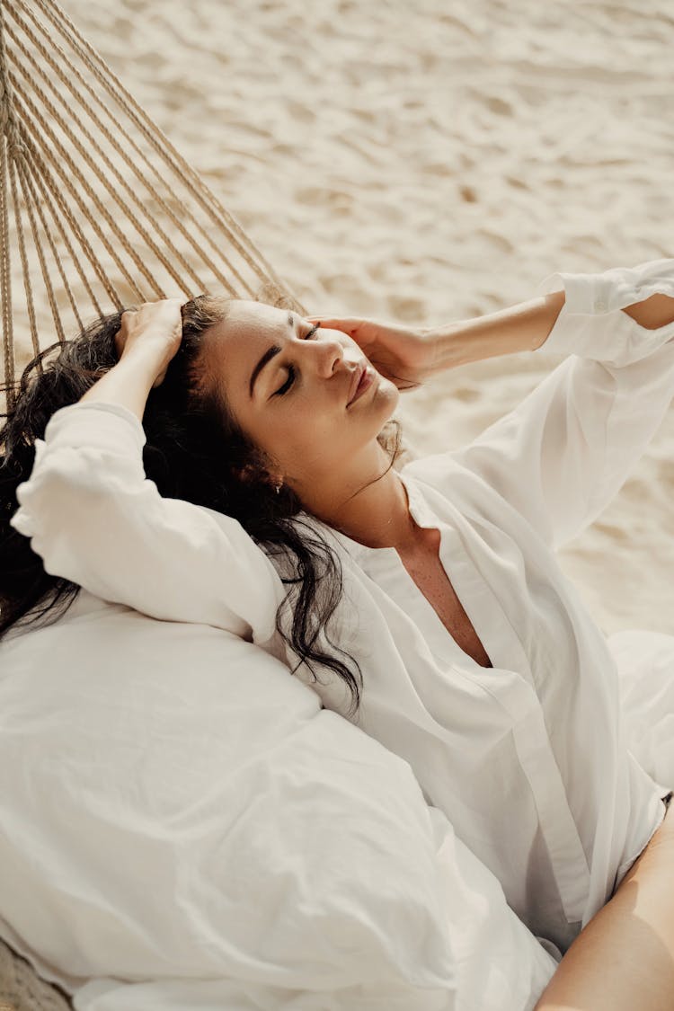 A Woman In A Hammock Touching Her Hair 