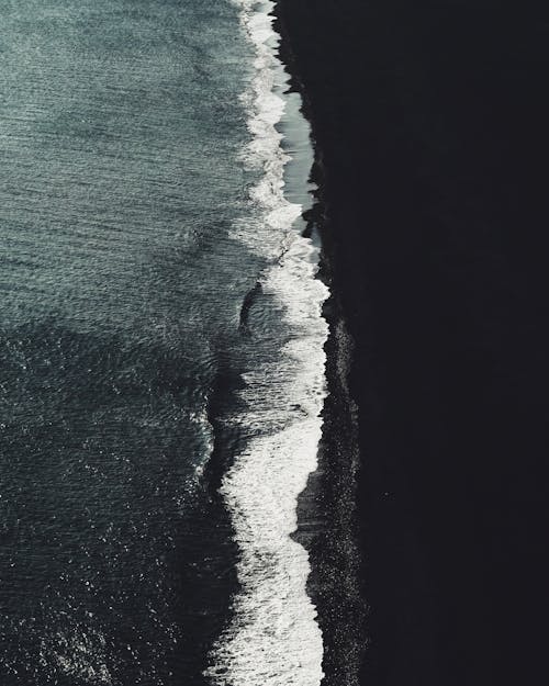 Drone view of ocean with foamy waves