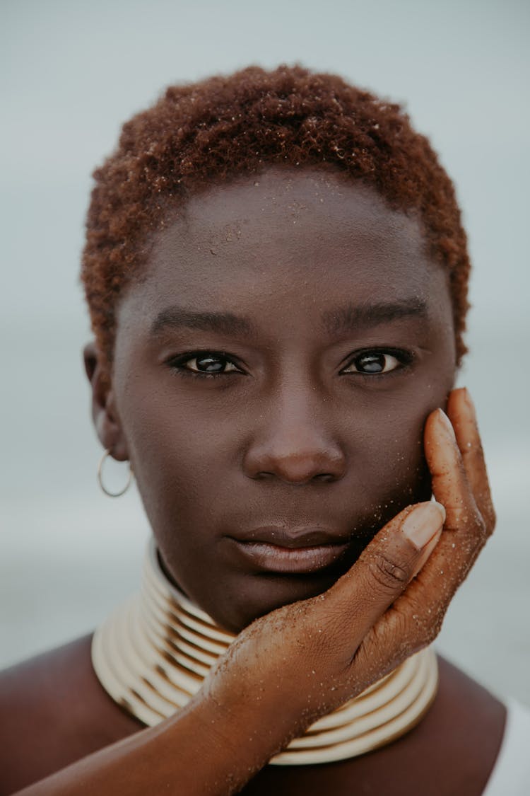 Hand Touching Unemotional Black Woman In Traditional Neck Rings