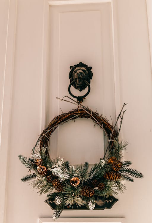 Free Decorative door wreath hanging on lion knocker Stock Photo