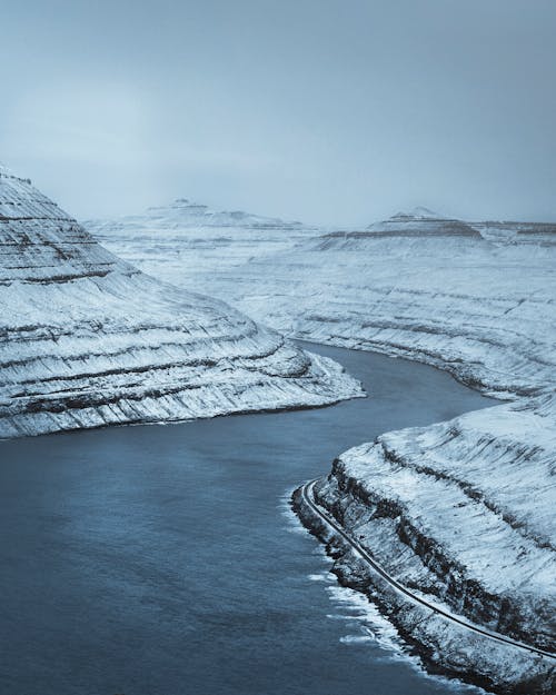 Frozen river stream flowing in mountainous terrain