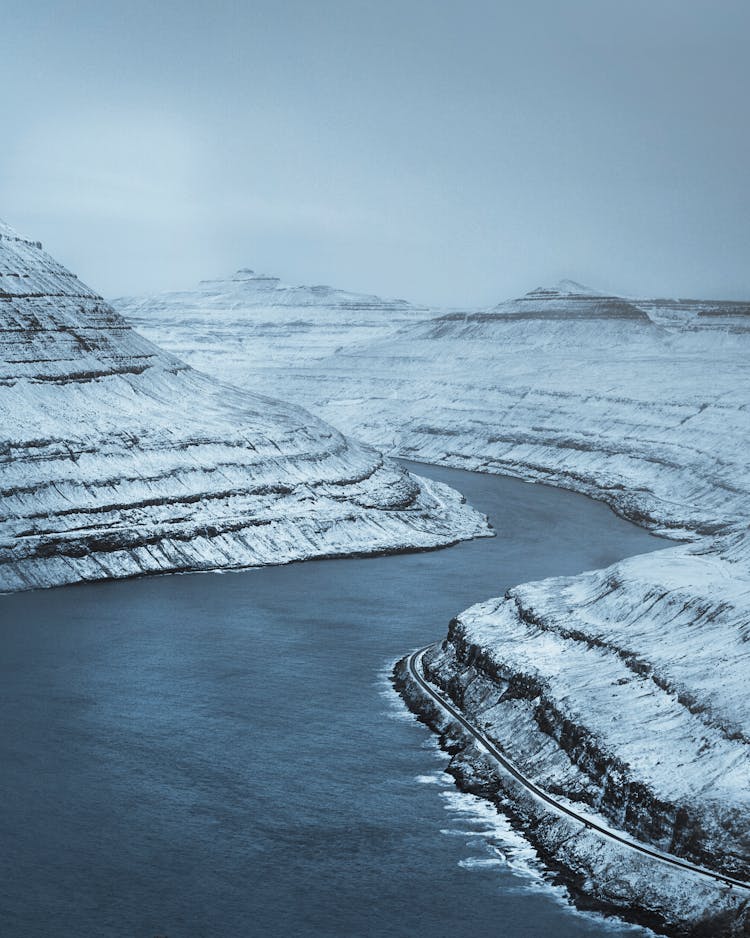 Frozen River Stream Flowing In Mountainous Terrain