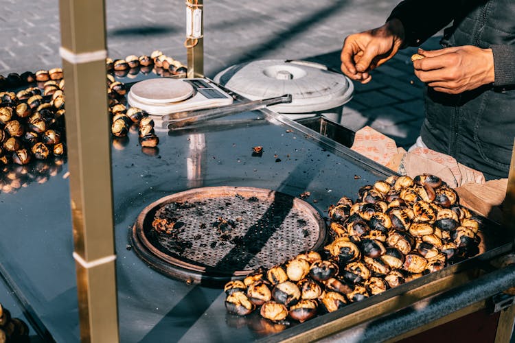 Crop Man Preparing Delicious Chestnuts On Street