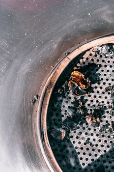 Burning coals on metal grill in daylight