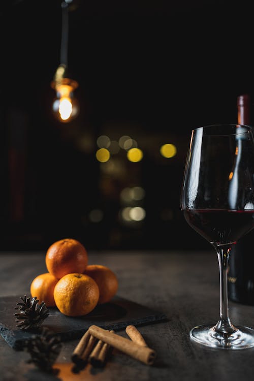 Still Life Photography of a Glass of Red Wine near Oranges