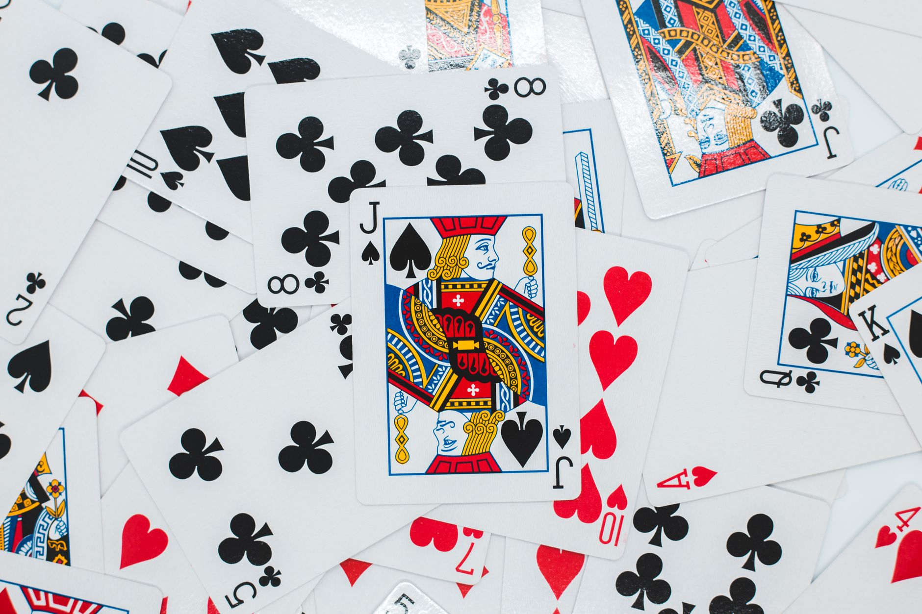 Overhead view of backdrop representing various playing cards with bright suit symbols and illustrations with glowing surface