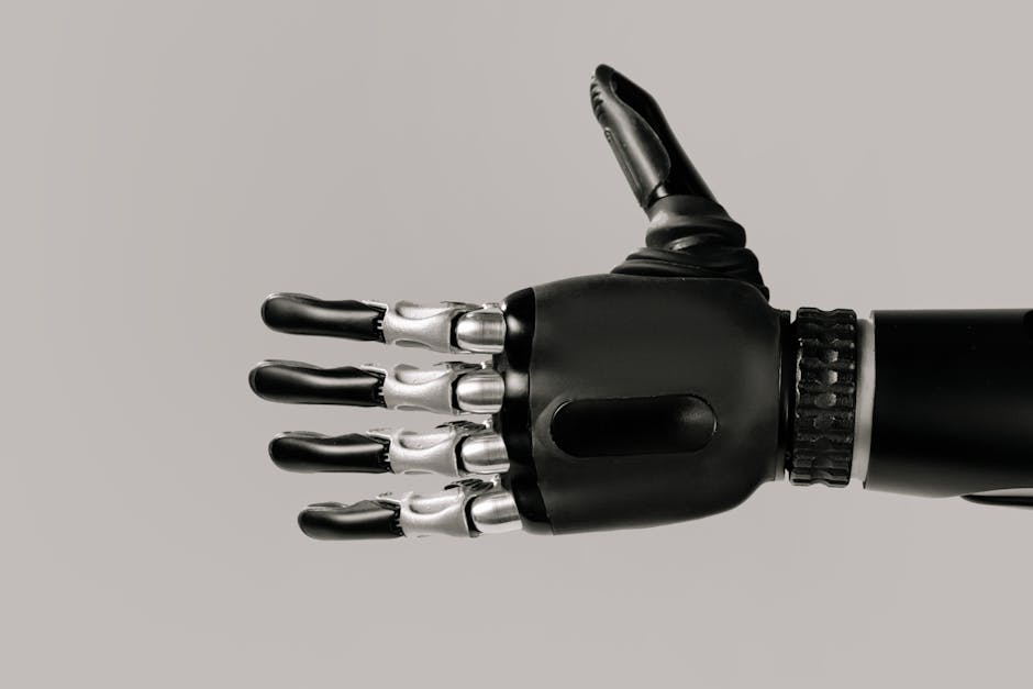 A detailed view of a sleek black and silver robotic prosthetic hand against a neutral background.