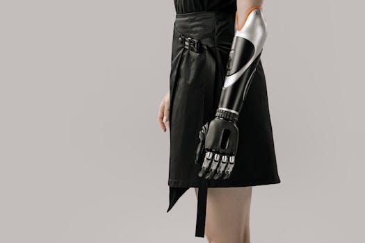 Close-up of a woman wearing a modern prosthetic arm with a stylish black skirt, set against a gray background.