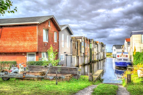 Photo of White and Blue Speedboat Beside Houses