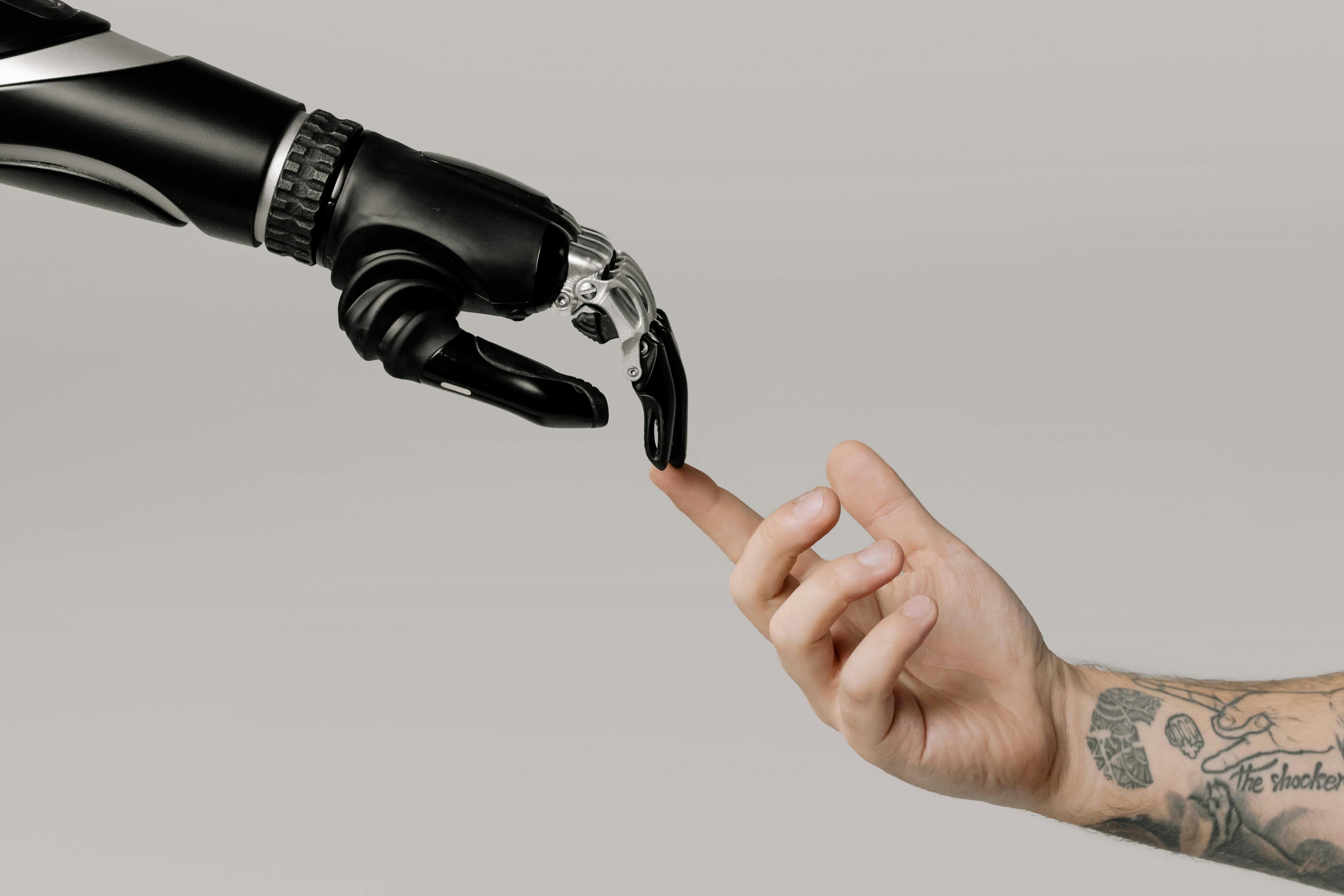 A human hand pointing at a bionic hand