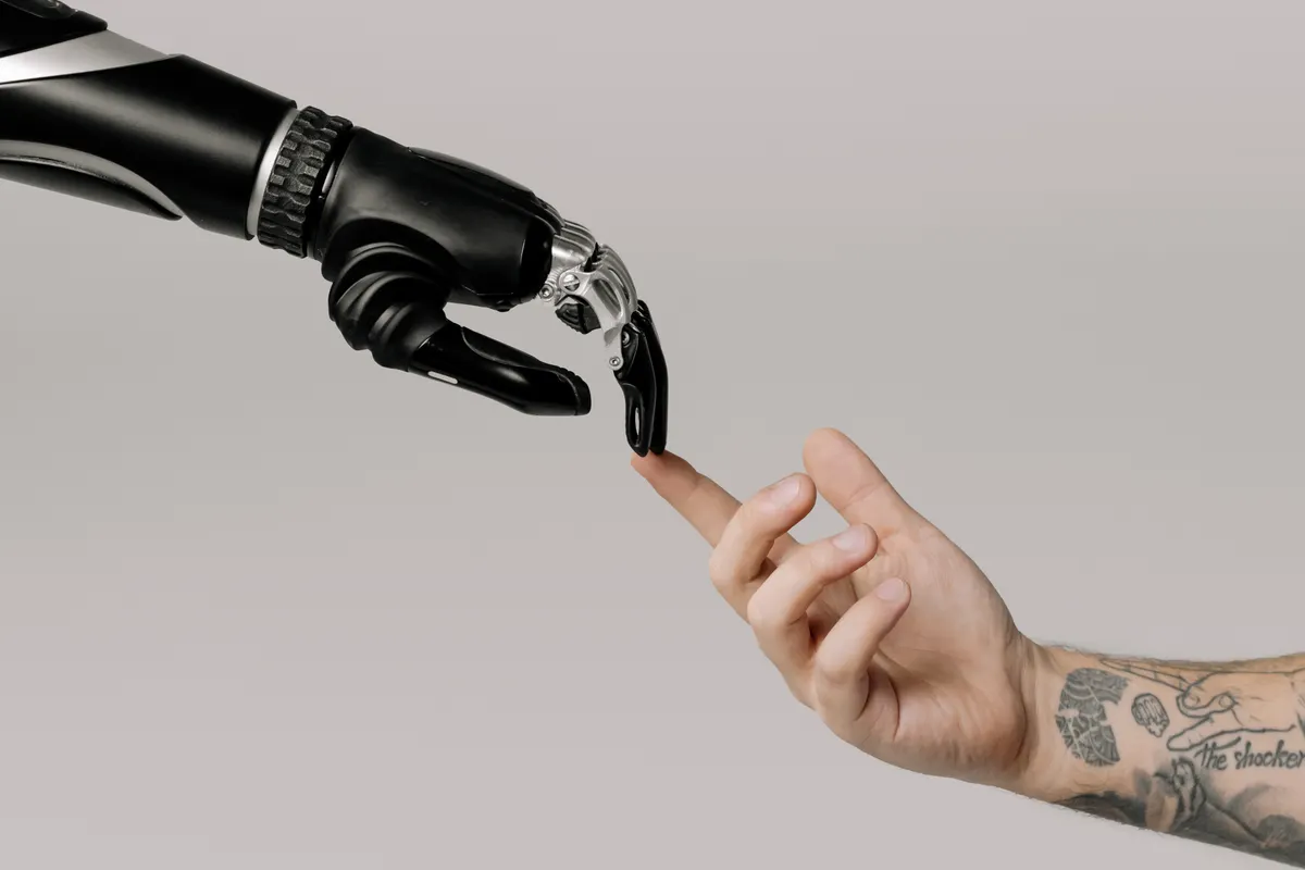 A robotic hand touching a human finger, representing automated content writing software and AI workflows.
