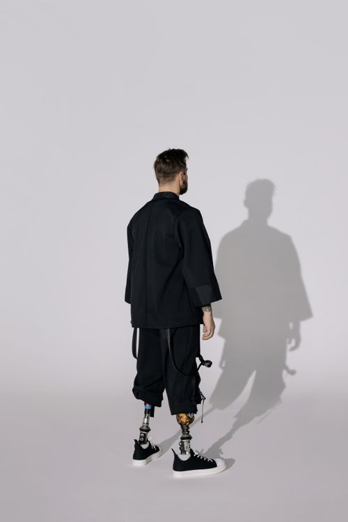 Free A stylish man with prosthetic legs, wearing modern fashion, stands confidently. Stock Photo