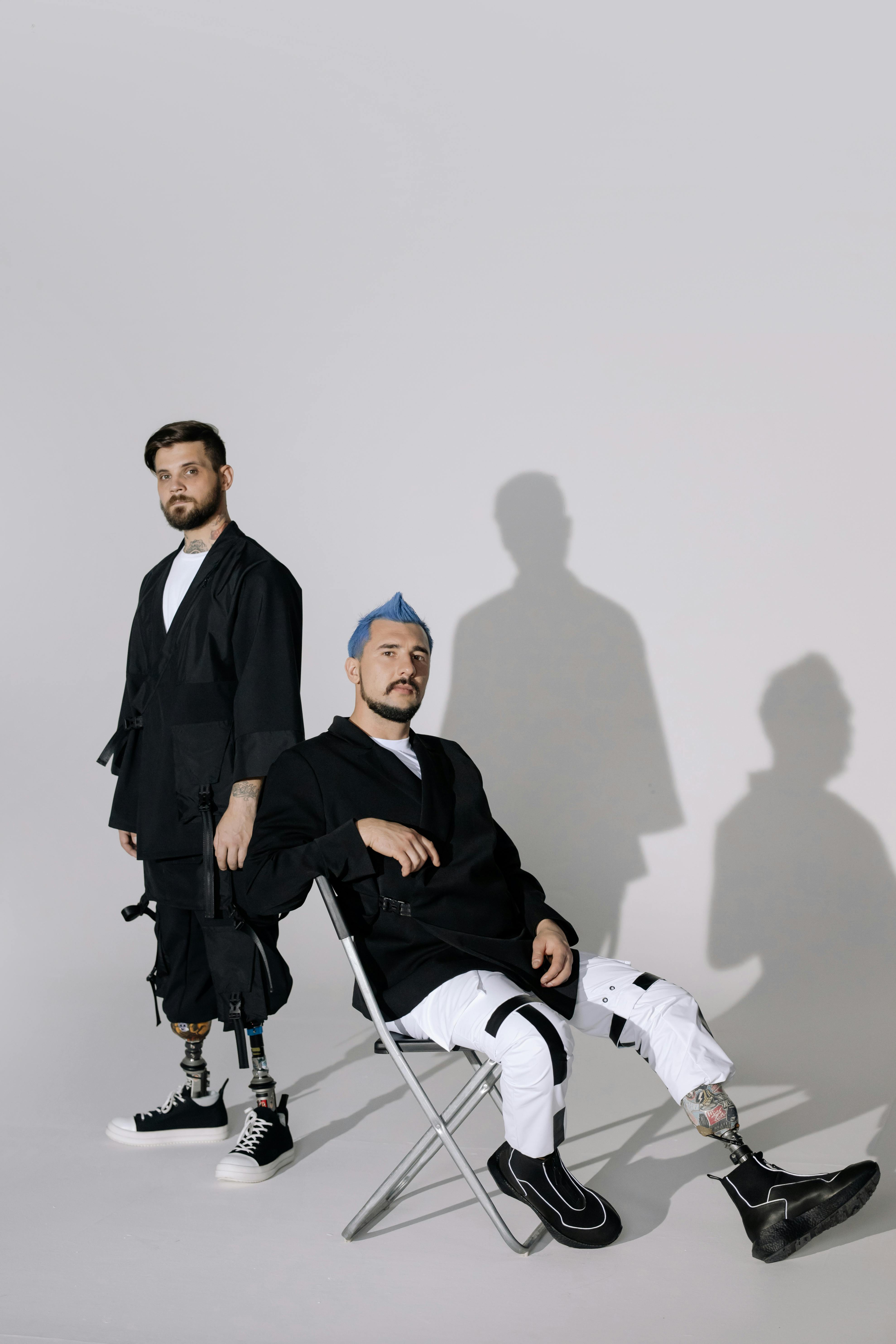 Kostenlos Mann Im Schwarzen Mantel, Der Auf Weißem Stuhl Sitzt Stock-Foto