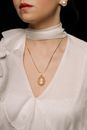 Woman in White Top Wearing Gold Necklace With Pendant