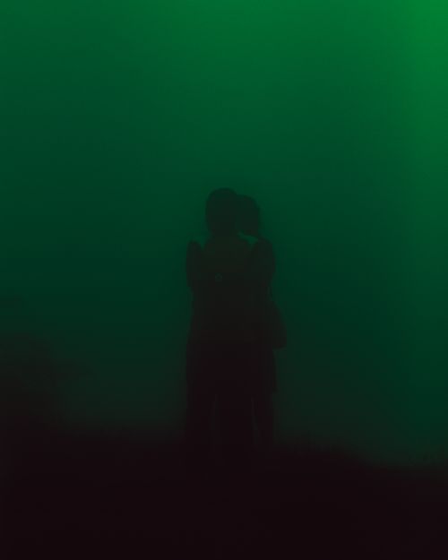 Free Silhouette of people embracing in a surreal, smoky green atmosphere, evoking mystery and emotion. Stock Photo