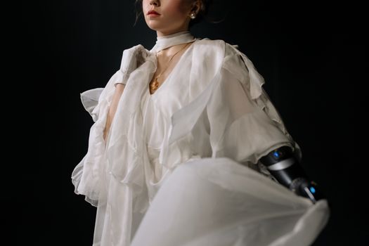 Stylish woman in a flowing white dress and advanced prosthetic arm, exuding elegance.