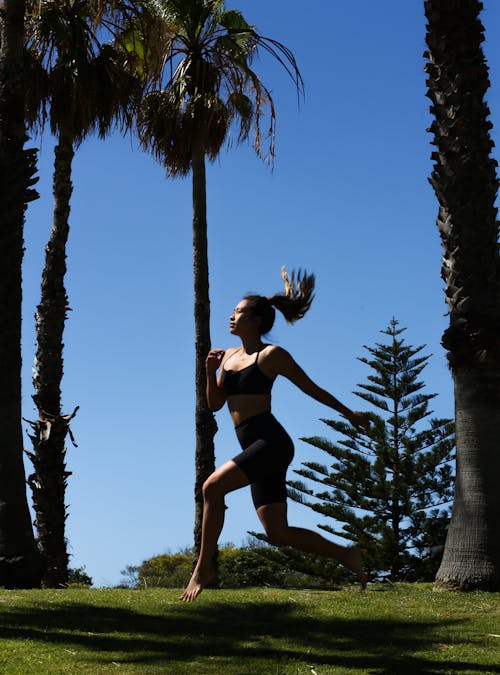 Woman Jogging among Palm Trees