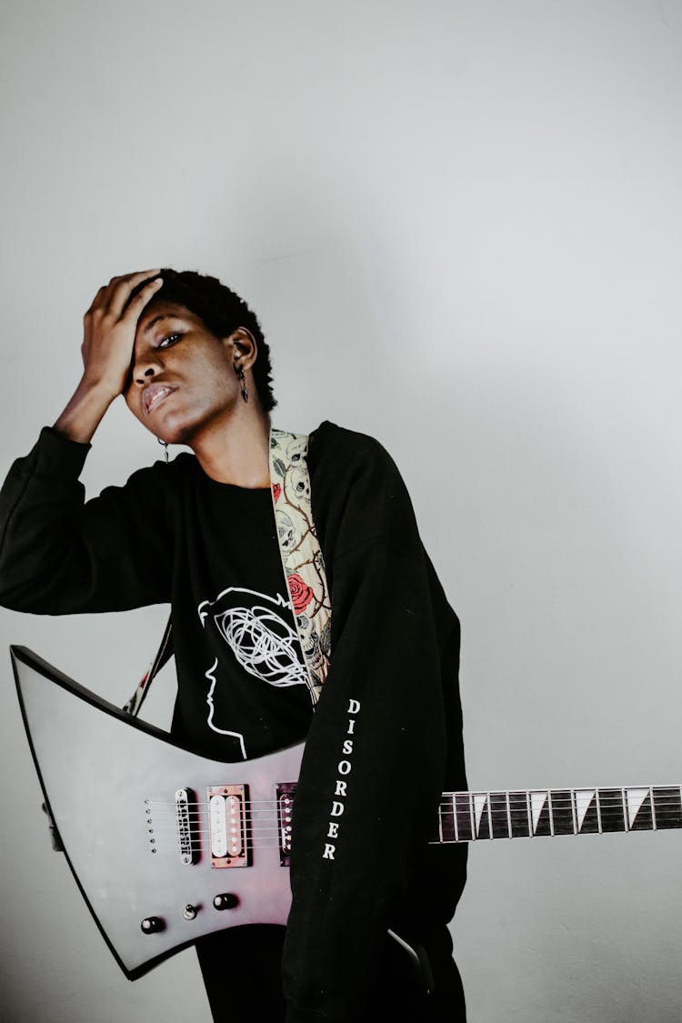 Black Musician With Electric Guitar On Light Background