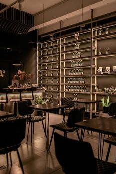 Elegant restaurant interior featuring modern design, with tables, chairs, and wall shelves.