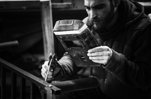 Grayscale Photo of a Man Welding