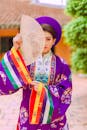 A Woman in Traditional Dress Holding a Hand Fan