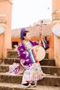 A Woman in Purple Kimono Sitting on the Stairs