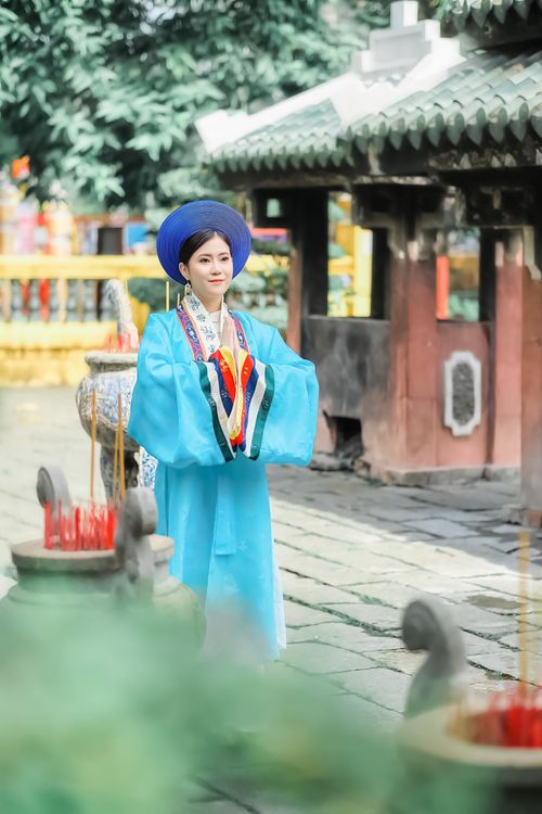 Free A woman wearing traditional clothing stands elegantly in an outdoor setting, embodying cultural beauty. Stock Photo