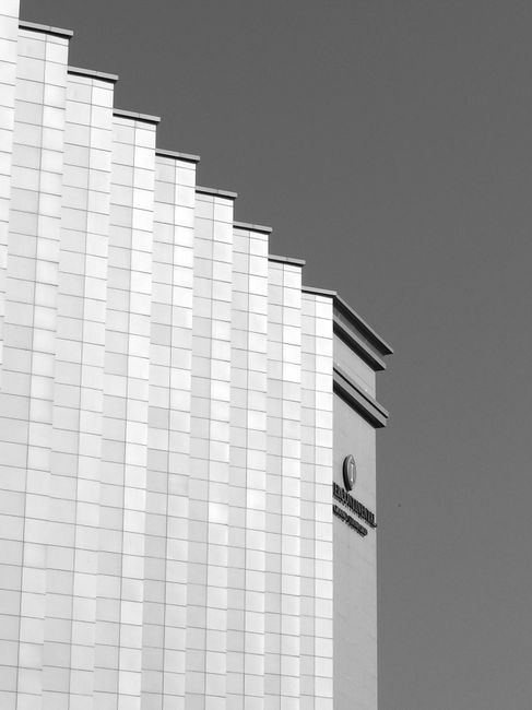 From below black and white of modern geometric architecture construction in street in daytime