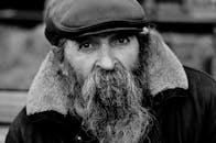 一位戴着帽子、留着长胡子的老人的黑白情感肖像