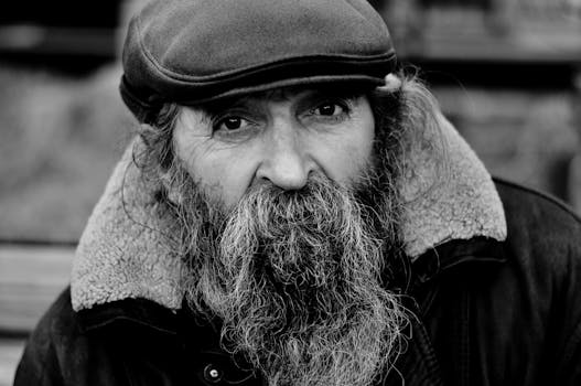 一位戴着帽子、留着长胡子的老人的黑白情感肖像
