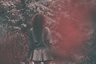 在梦幻而神秘的森林中，一名年轻女子背对着她站着