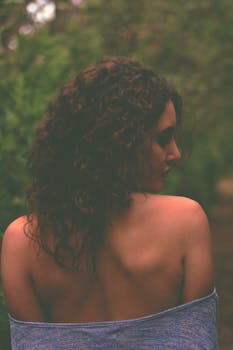 留着露肩卷发的女人置身于大自然之中