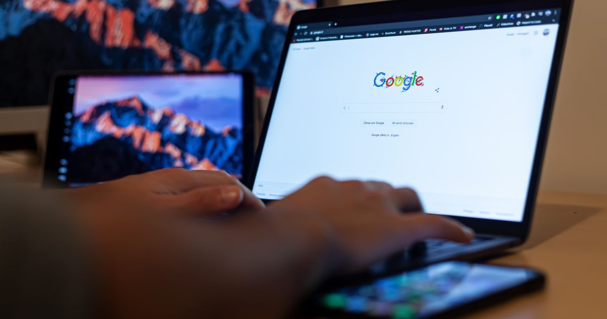 Hands typing on a laptop with Google on screen in a remote-work setup