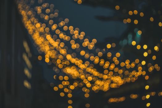 Warm yellow bokeh lights against a dark backdrop create a magical, abstract night scene.